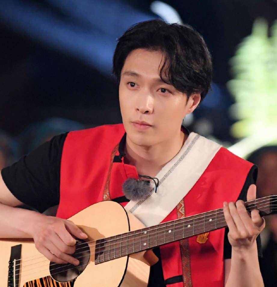 热爱音乐的张艺兴到了佤族村落也不忘穿着佤族服饰为村民弹奏一曲.