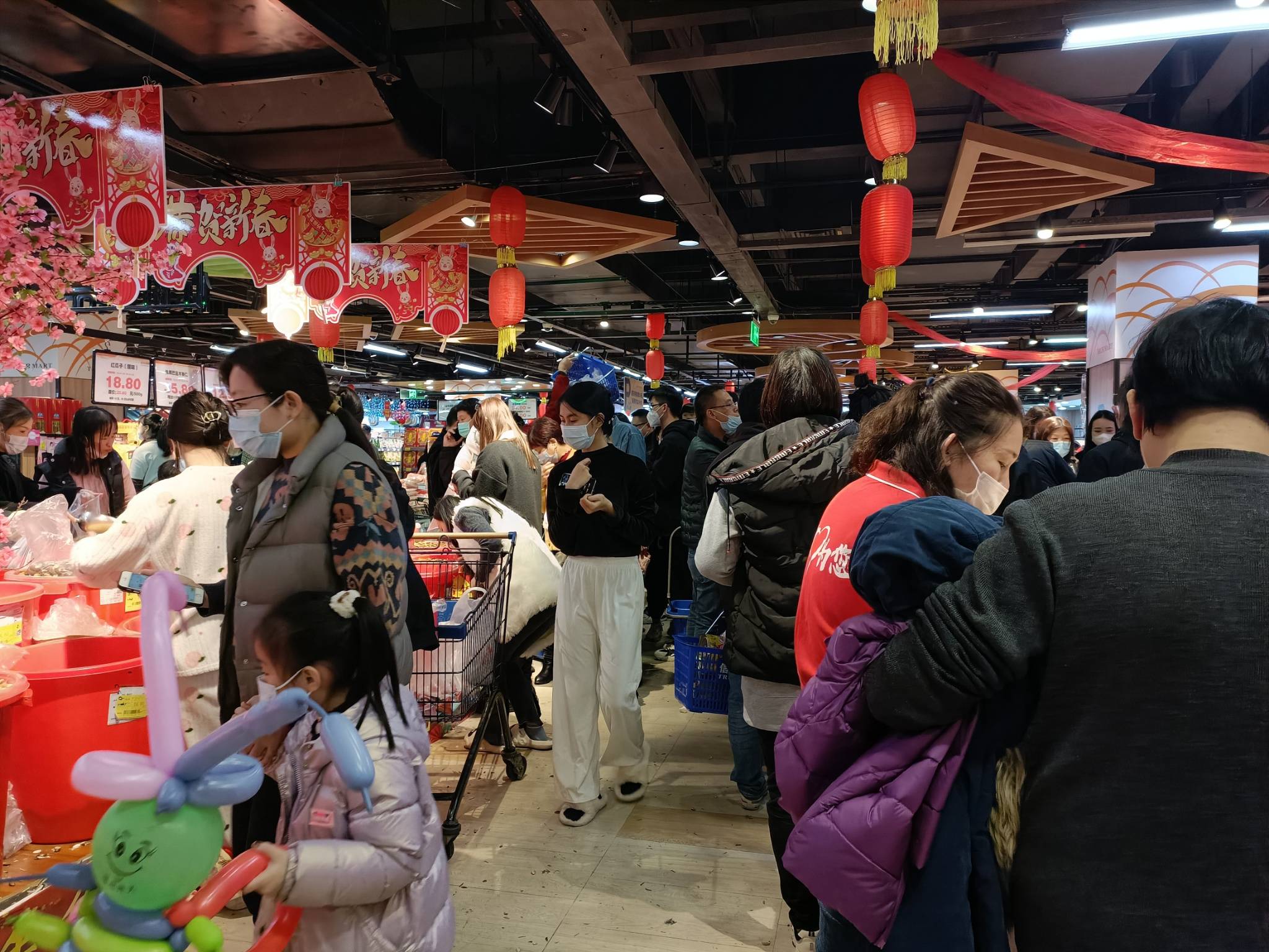 通往超市的道路车辆,人流熙熙攘攘,造成临时性拥堵,有开小车的市民被