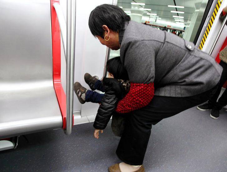 大妈抱娃＂尿＂在地铁车厢上,父母没素质,很难教出优秀的孩子