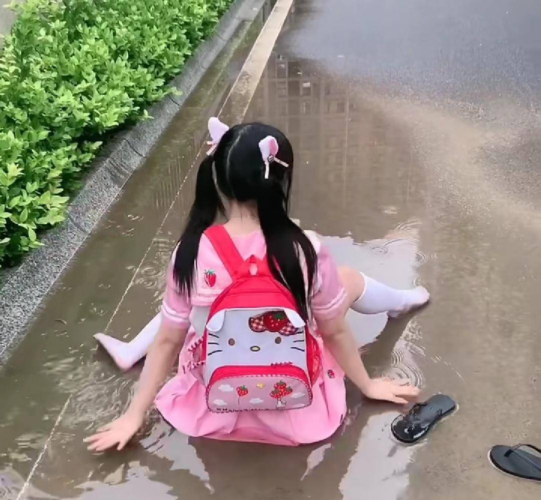 双马尾萝莉穿着粉色学生装坐在水洼里,不会湿吗?