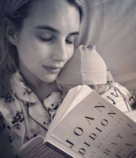 照片中她穿着一套丝质的睡衣,一手抱着宝宝,一手拿着一本书,虽然这本