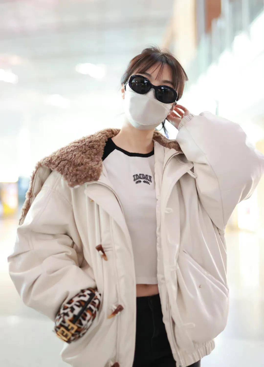 李菲儿走机场穿白色翻毛领夹克搭黑色牛仔裤清新时尚显身材