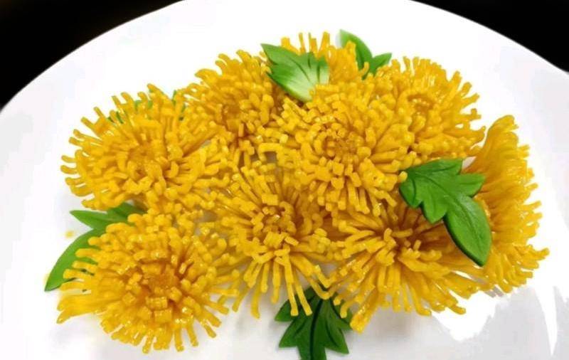 鸡肉菊花锅留底油,放入烧汁和水淀粉,熬制浓稠后淋在控油后摆盘的猪肉