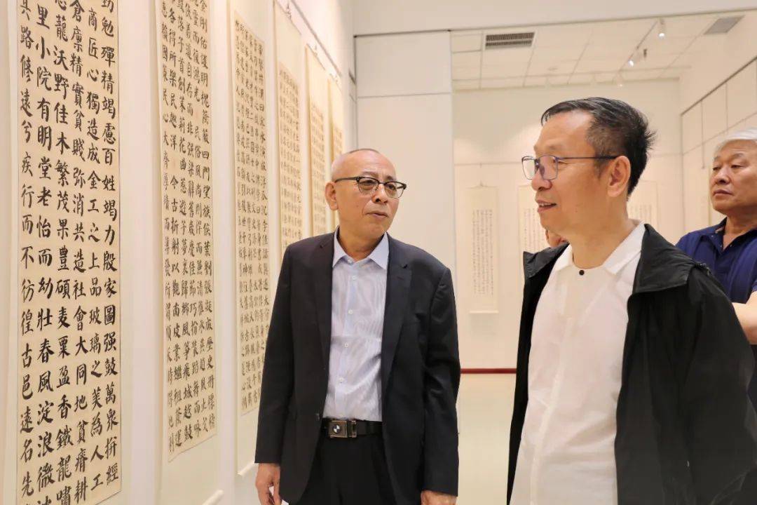 张建会,王炳学在展览现场观看作品左起:宋紫依,李松涛,康柏林,喻建十