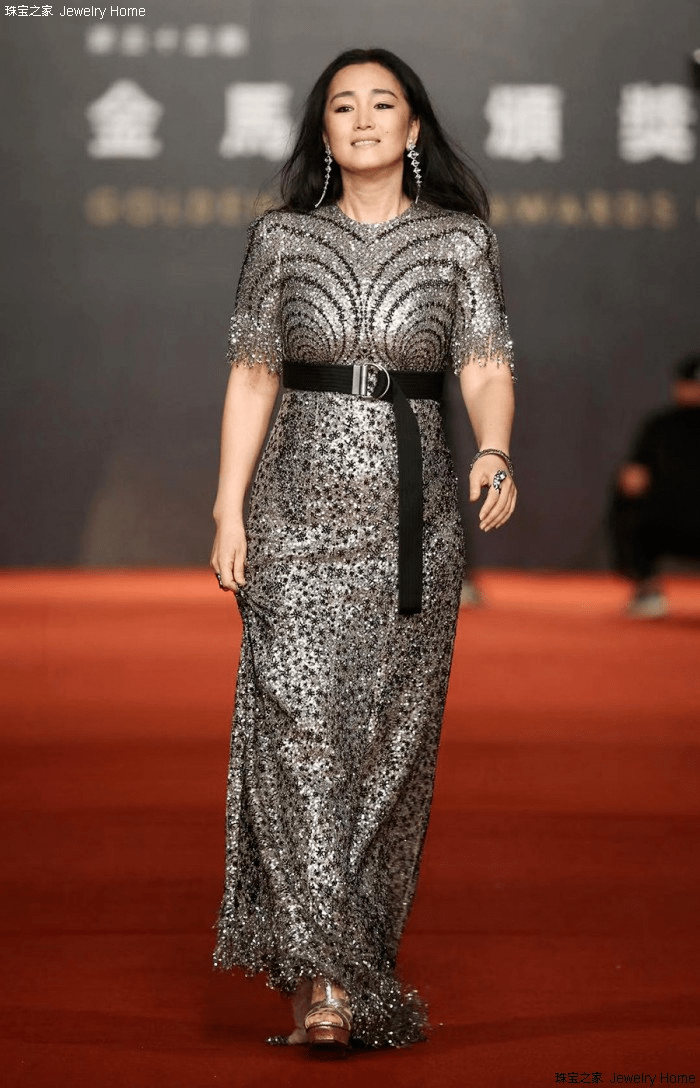 照片中可以看到巩俐上半身穿的是一件黑色紧身衣搭配的一条长裙,这一