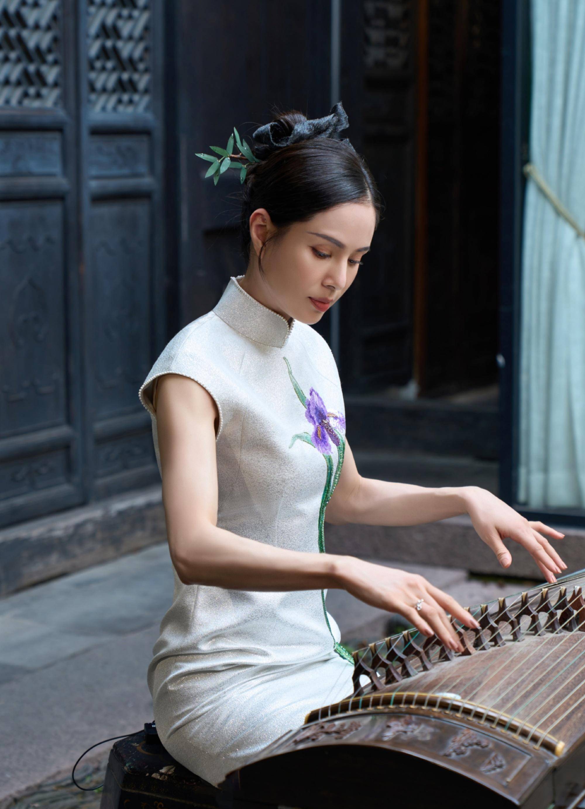 她的头发扎起来梳成古代女子的发型与旗袍的造型十分契合