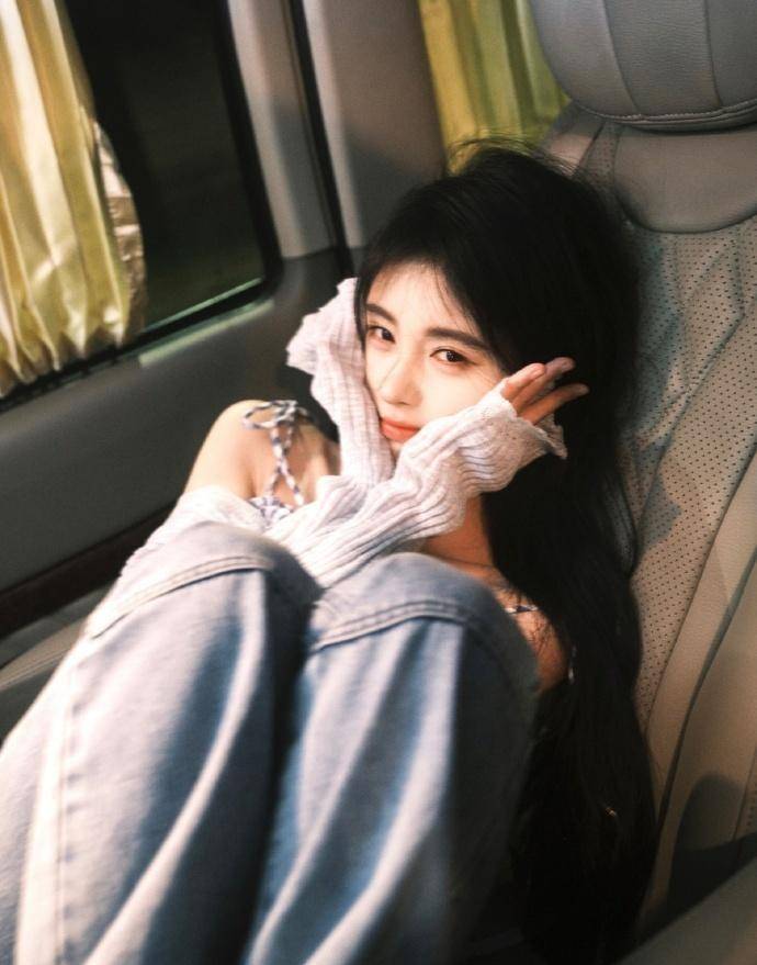 对着镜头做出各种可爱的表情,时而吹起齐腰的长发,时而摆出剪刀手造型