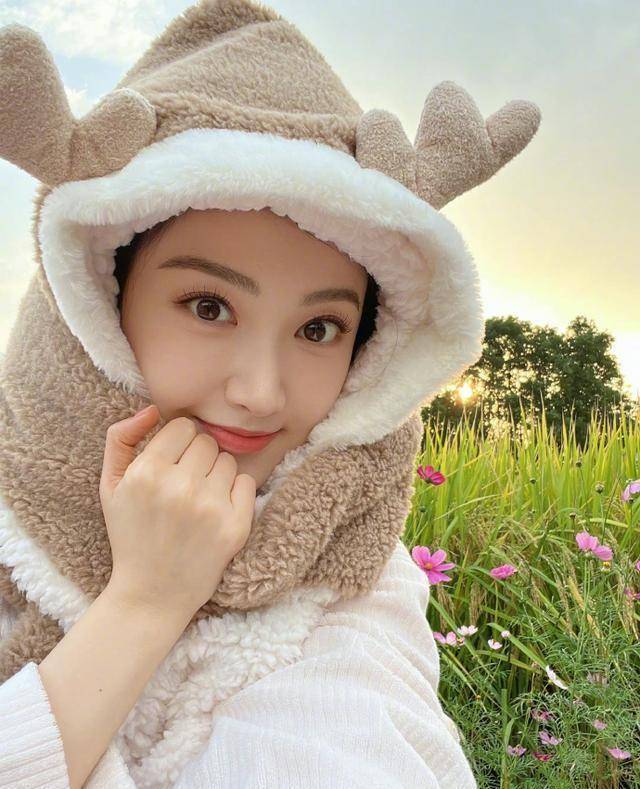 中的景甜戴着小麋鹿围巾帽,置身秋日花丛田野中,还不时嘟嘴卖萌超可爱