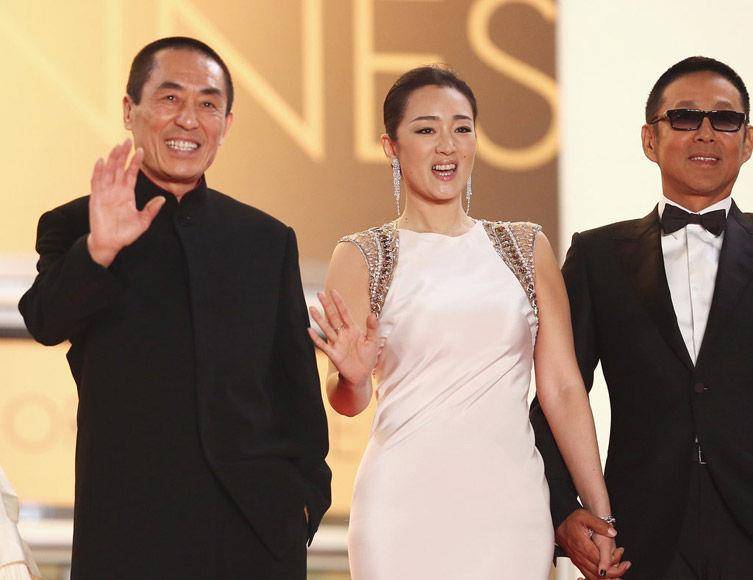 巩俐和陈道明携手走红毯,穿着优雅的白色连衣裙,张艺谋束手无措地爆笑