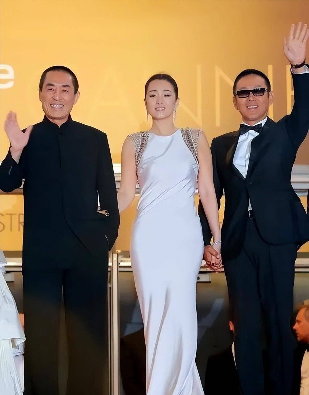 巩俐和陈道明携手走红毯,穿着优雅的白色连衣裙,张艺谋束手无措地爆笑