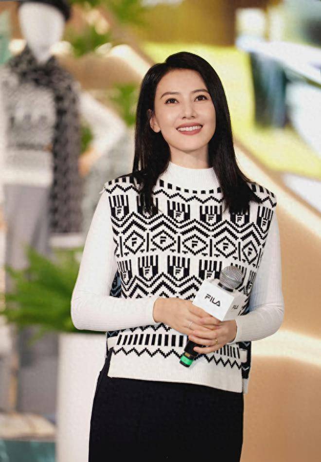 公开的照片中,高圆圆身穿圆领几何毛衣背心,内搭白色衬衫,时尚又减龄.