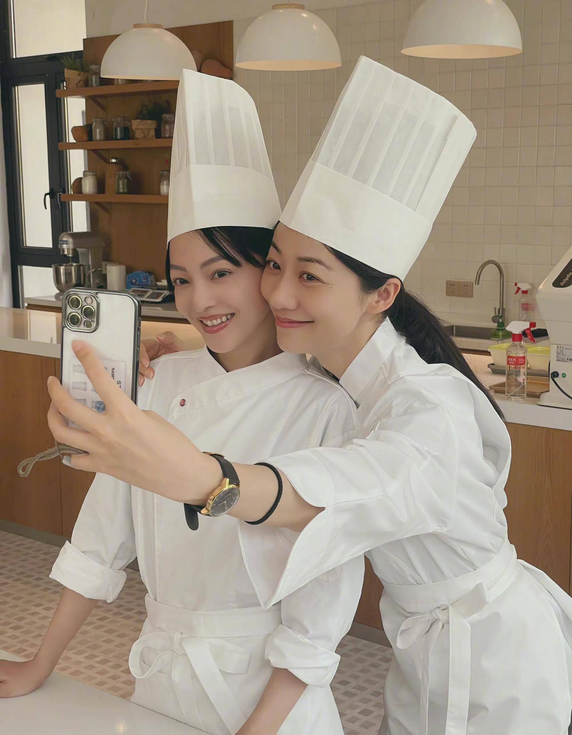 韩雪和张韶涵两人都戴着厨师帽穿着厨师的服装,两人脸贴脸合照看起来