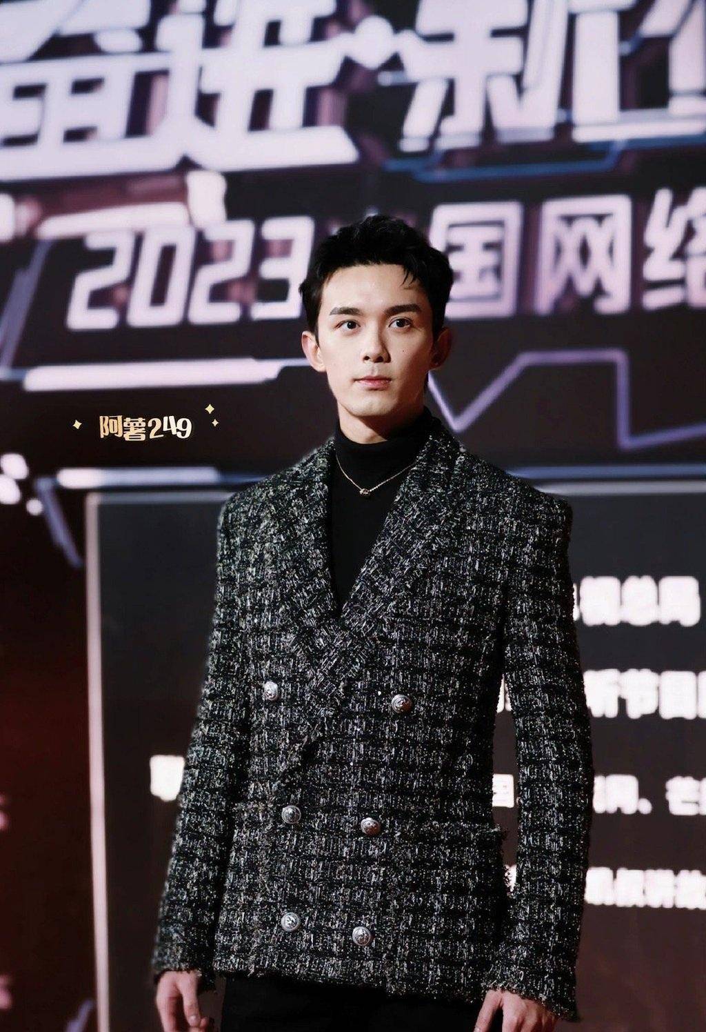 吴磊里面穿黑色高领毛衣,外面搭配黑白格纹西装,下身穿着黑色紧身裤