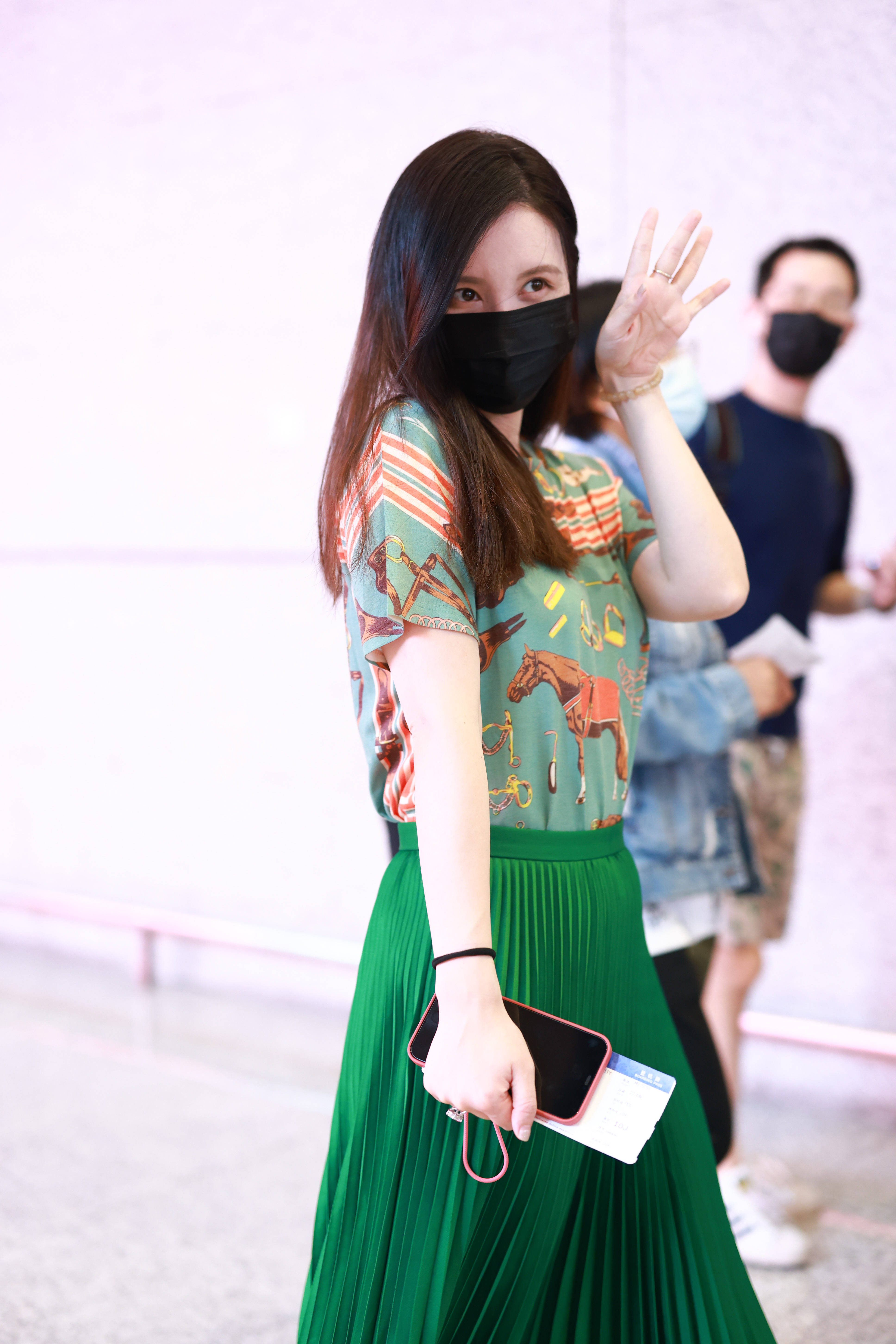 1/ 12 2021年6月27日,上海,张萌亮相机场,她身穿绿色印花t恤搭配百褶