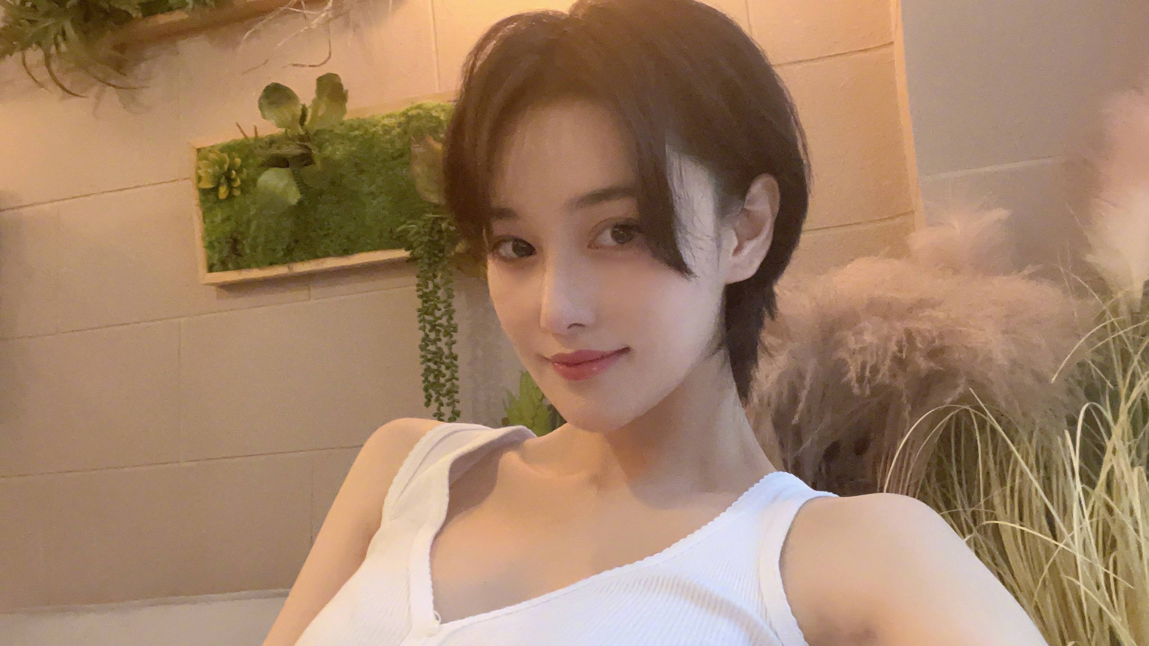 张馨予穿着清凉与桃子树合影 皮肤白皙酷飒迷人