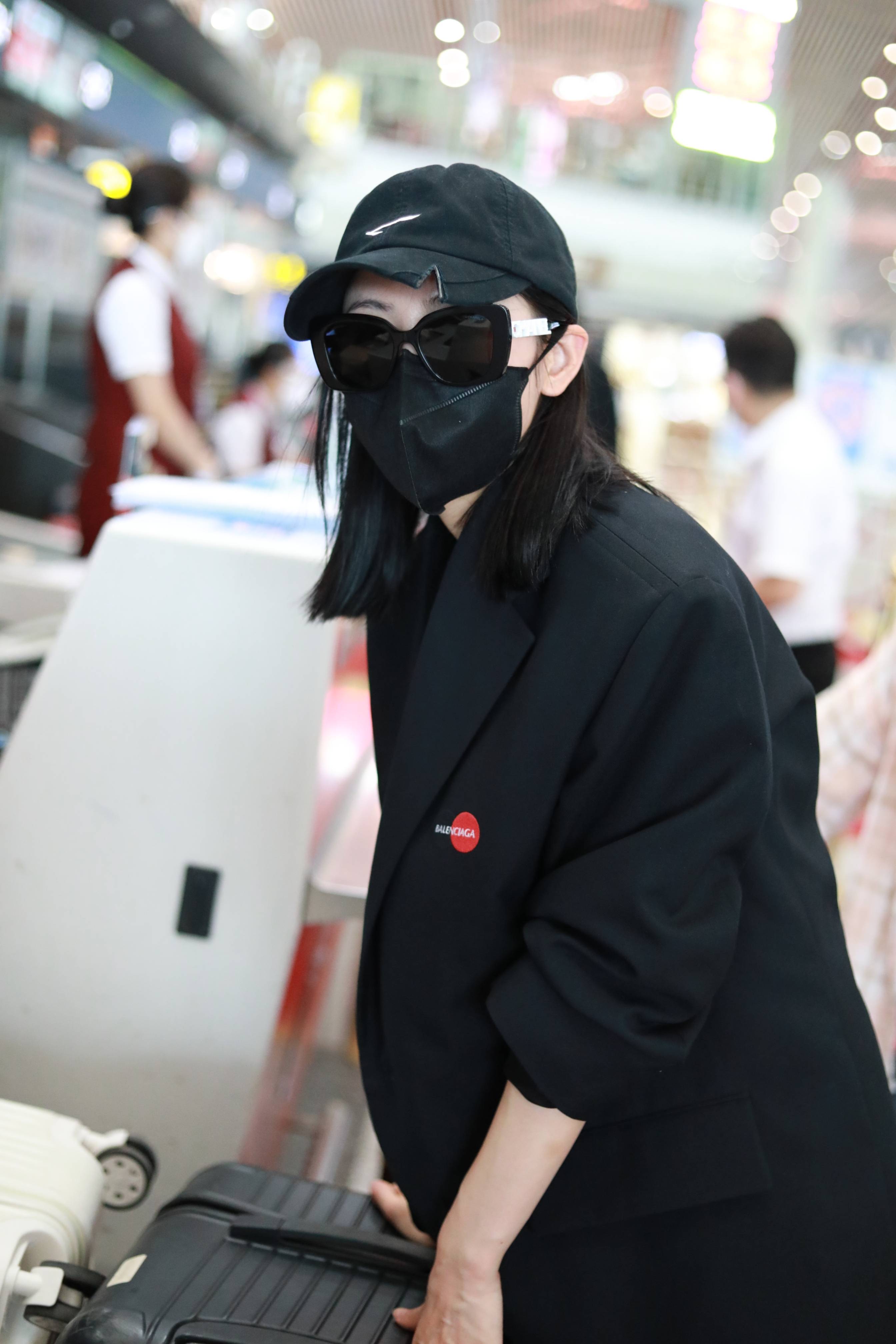 2021年8月16日,北京,张天爱现身机场,身穿黑色西装搭喇叭裤飒气复古