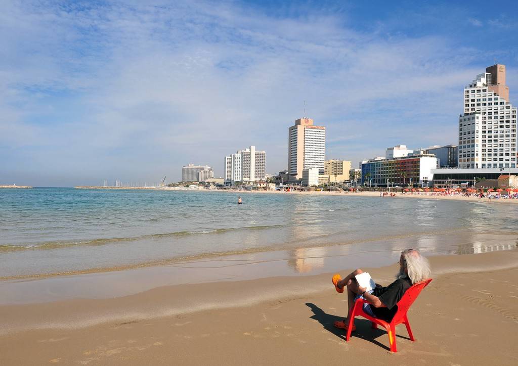 以色列特拉维夫美不胜收 男子海滩惬意看书