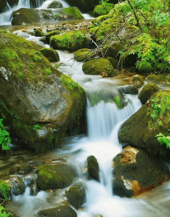 脚下是流水淙淙的鸣响,头上是蓝天白云,一束阳光洒落在水面上.