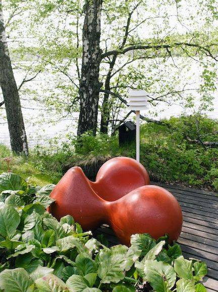 湖畔之家的外部空间,室外的红色家具是阿尼奥设计的"番茄椅",从任何