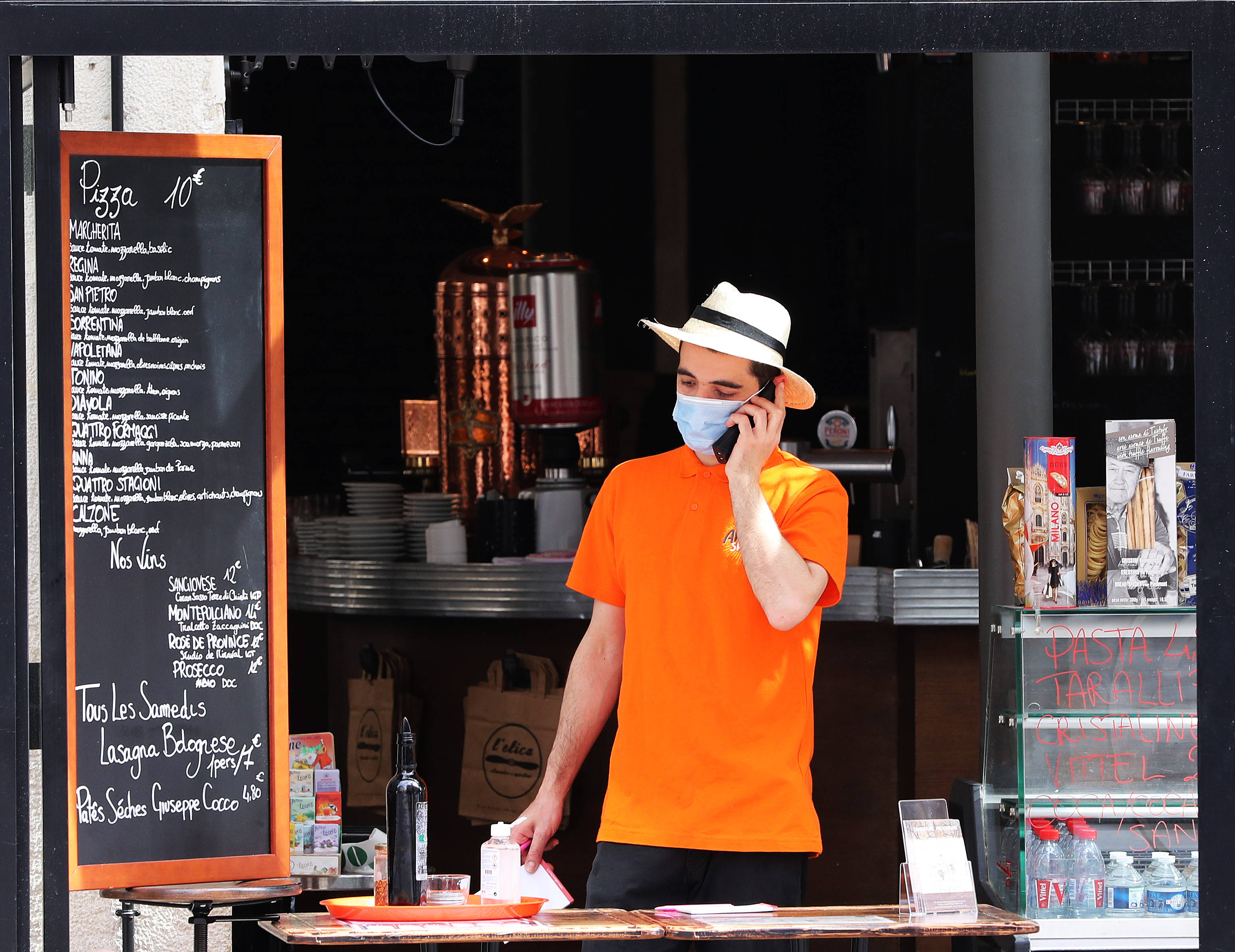 这是5月22日店员在法国巴黎一家餐馆为顾客提供外卖服务的资料照片.