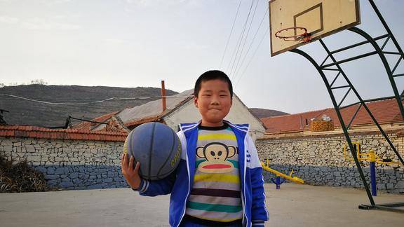 山东烟台农村篮球场上的小男孩很多人的童年像他一样