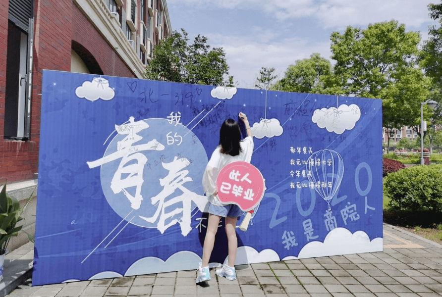 在商学院门口,我们为毕业生准备了"青春不毕业"主题签名墙.