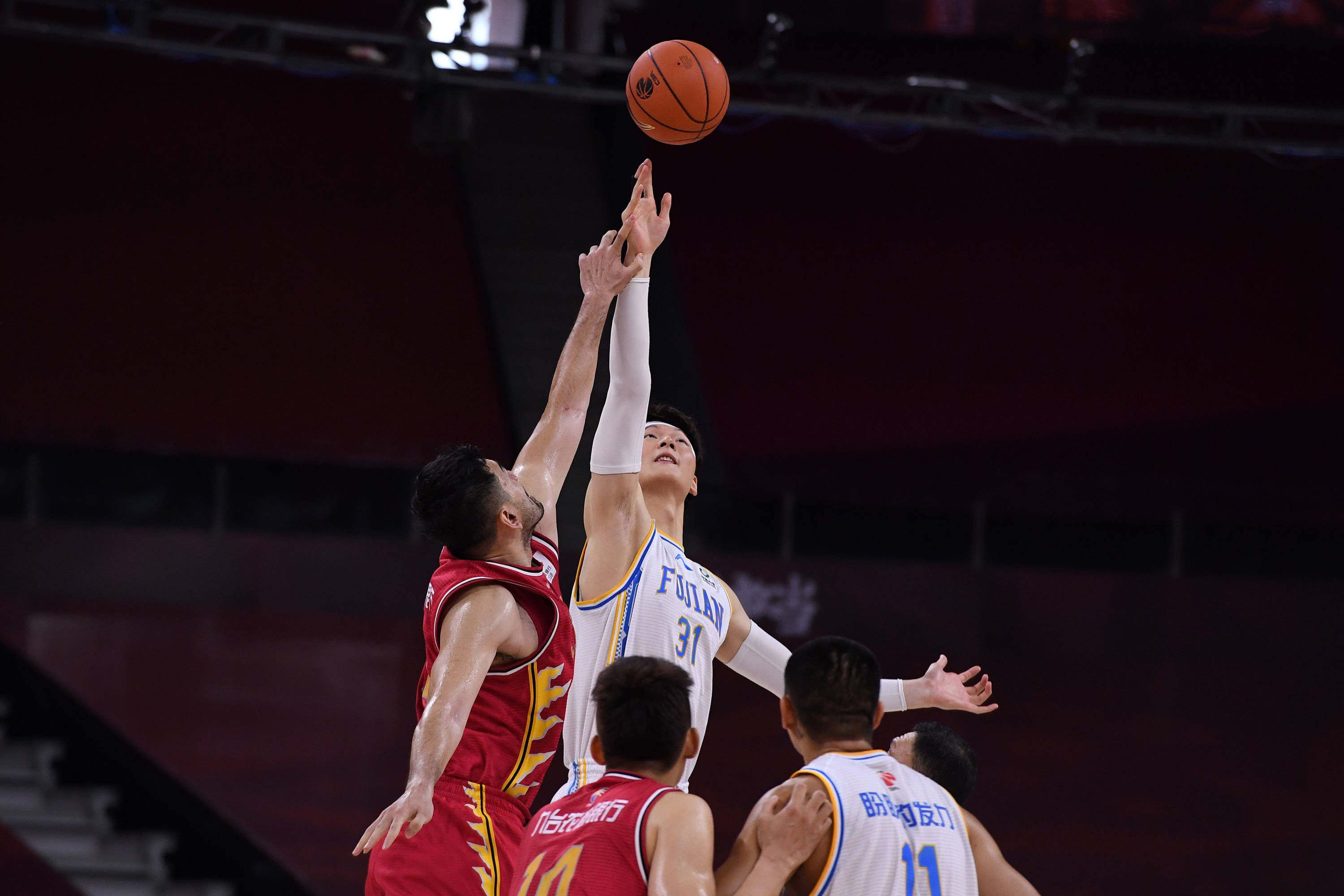 6月23日,福建豹发力队球员王哲林(上右)在比赛中跳球.