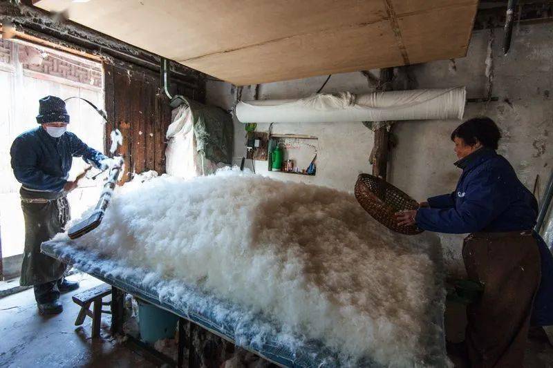 小时候盖新被子也是很非常幸福的事一堆棉花被压成一条整整齐齐的被褥