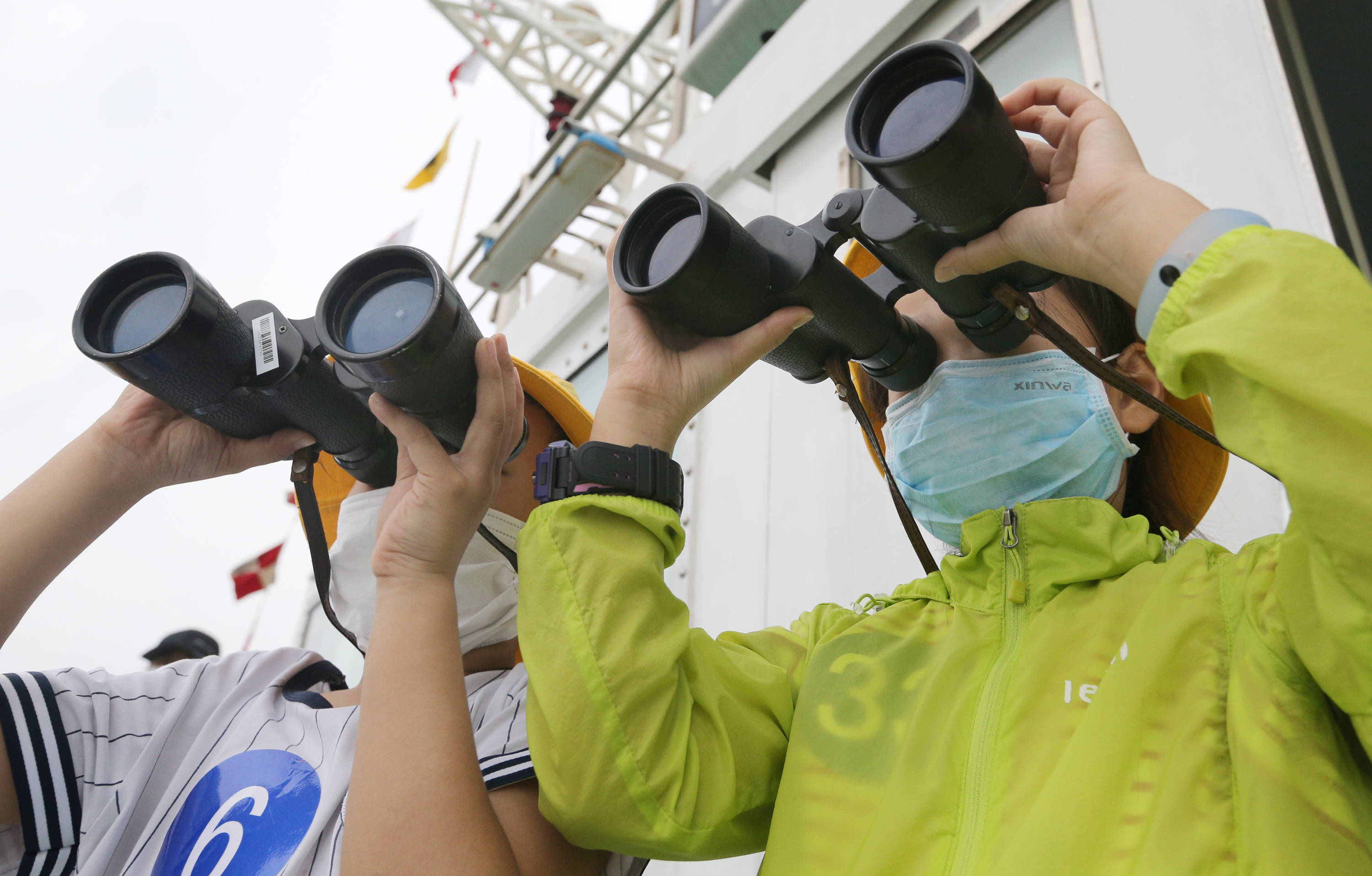 在江苏连云港海事局"海巡0611"轮上,登船参观的学生用望远镜观察海况