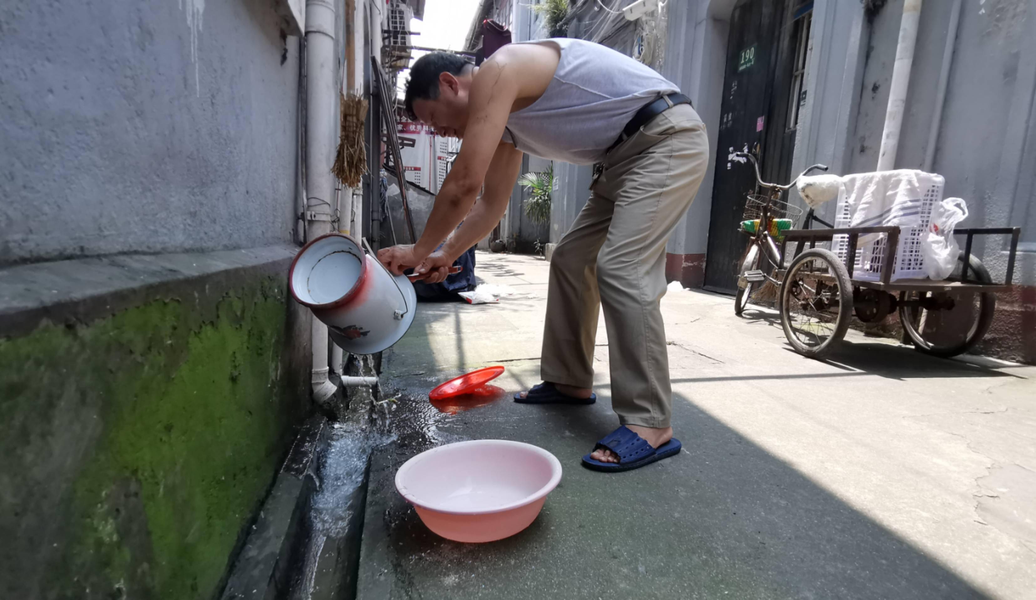 "杨浦区大桥街道周家牌路居民区里,65岁的汤阿姨一边洗刷着痰盂,一边