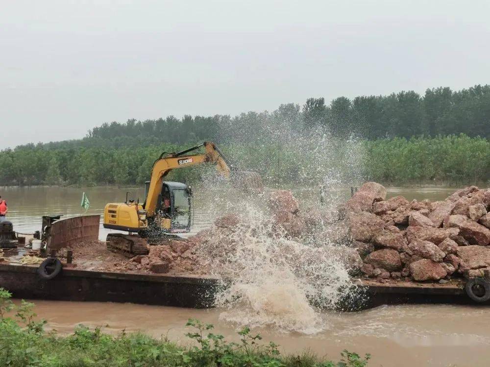 机将第一块大石从运输船上抛入水中,大口村抱鸡母洲段崩岸险情抛石镇