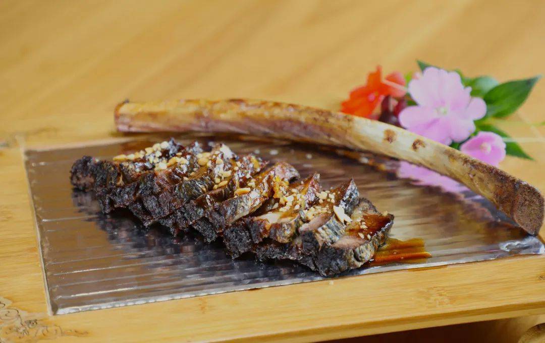 特色古法烤牛肋摆盘别致,牛肉片旁还有牛骨装饰.