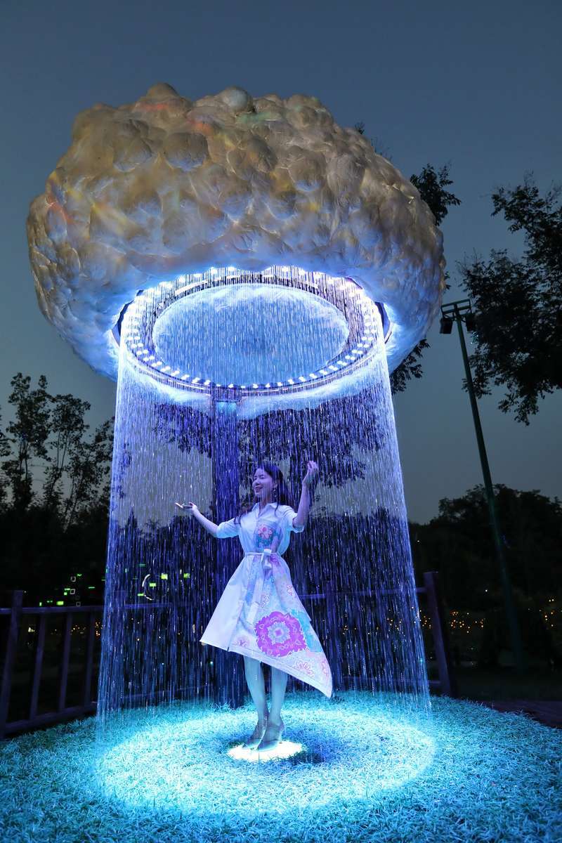 8月20日晚,北京玉渊潭公园,一名参观者在体验灯光秀装置.