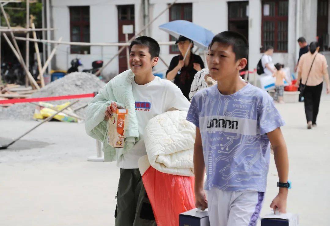 乐成一中初一新生,扛着棉被往宿舍走去.