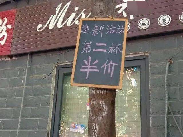 被附近店家变成了树挂,树干被人钉上钉子,挂上了小黑板,这也真是纯