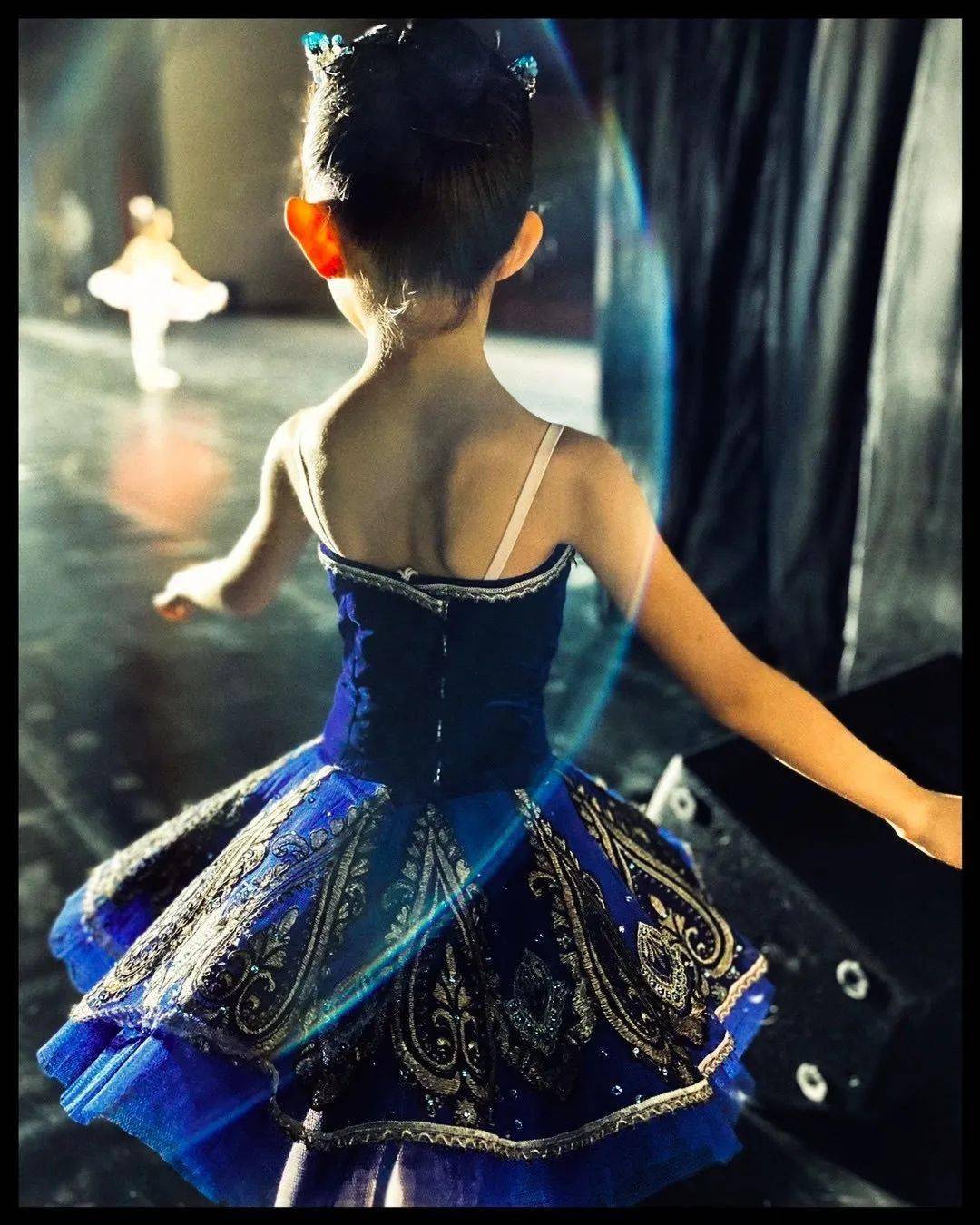 面对着空旷的偌大的观众席留下的稚嫩背影;另一张是一个女孩站在舞台