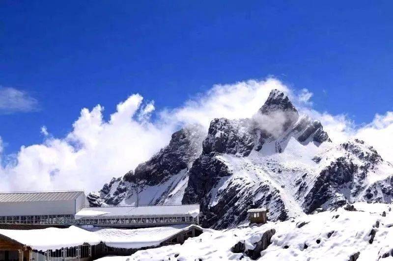 谷玉龍雪山冰雪融化成河水從雪山東麓的一條山谷而過因月亮在藍天的