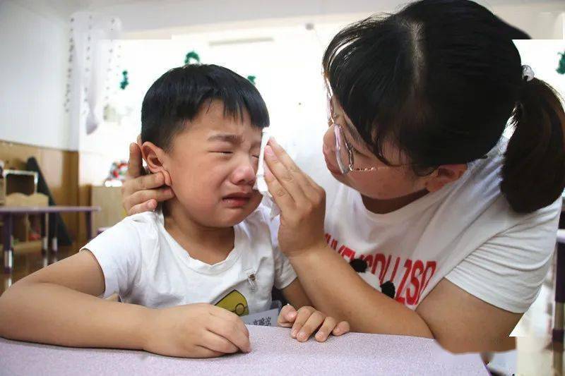 小班幼儿刚来幼儿园的时候许多小朋友哭闹着在地上打滚不进教室.