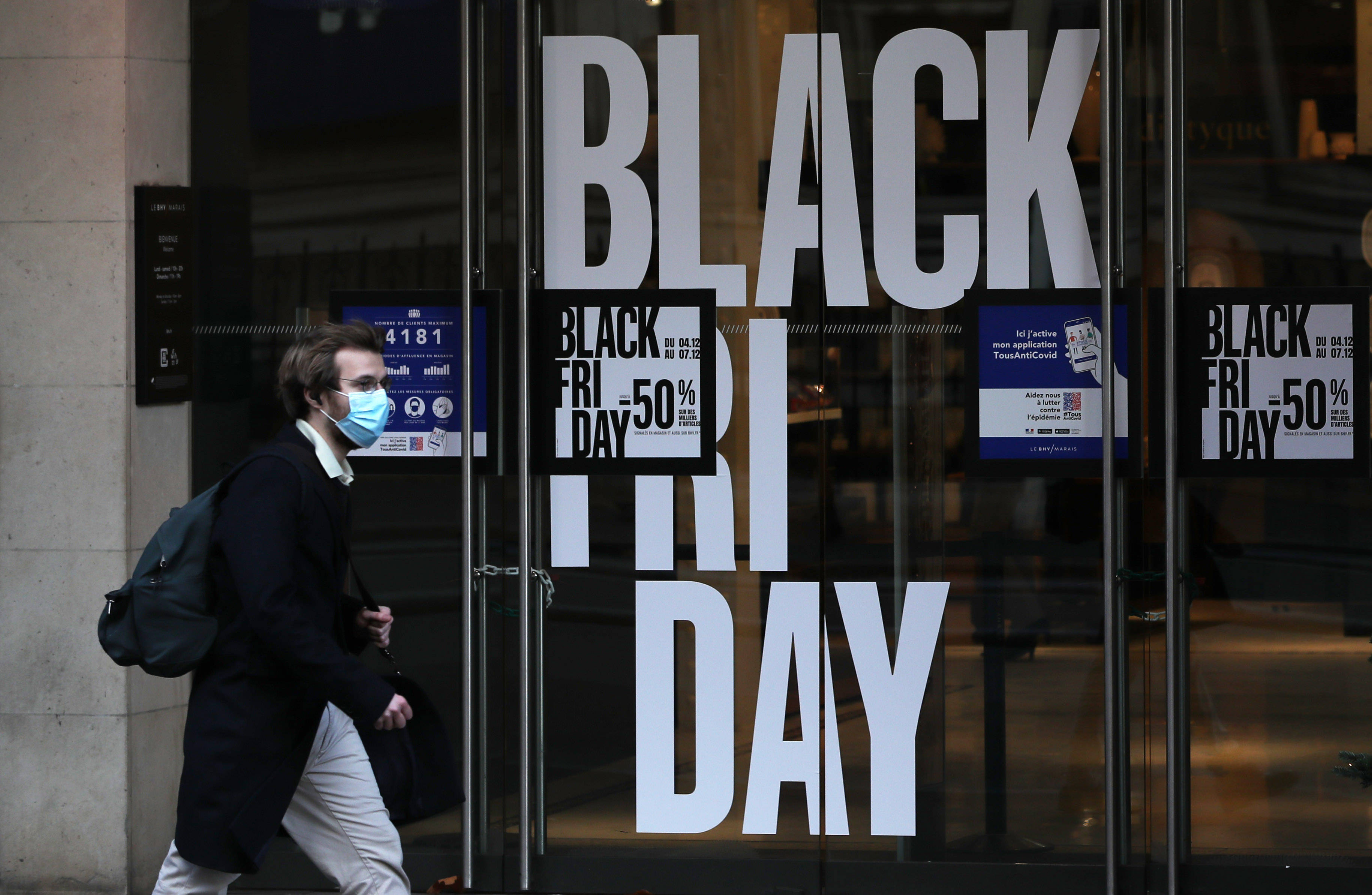 12月4日,一名男子走过法国巴黎街头一处"黑色星期五"购物促销广告.