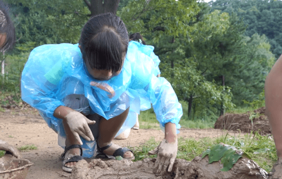 周禹安,只见光着脚丫子,在泥水踩着水,挖着泥,很是快乐