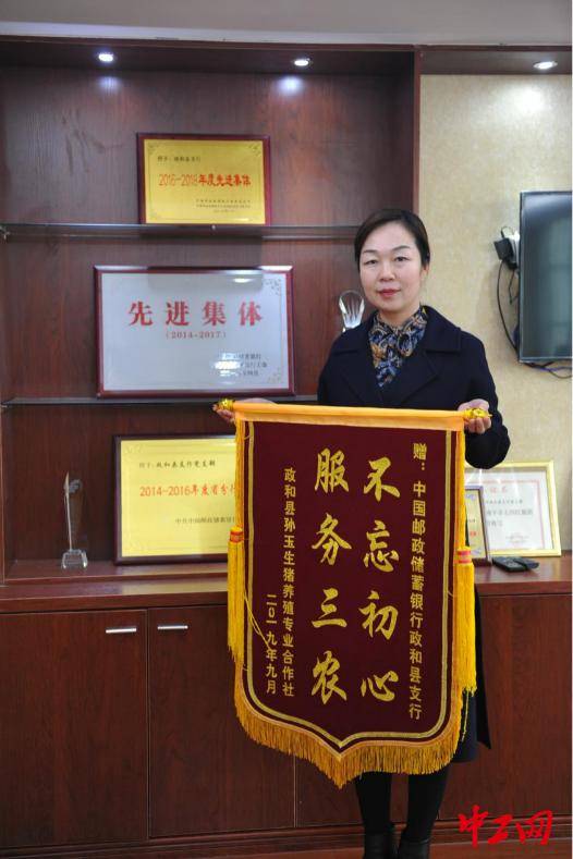 中国邮政储蓄银行政和县支行行长吴小琴向记者展示锦旗 李逸萌摄"感谢