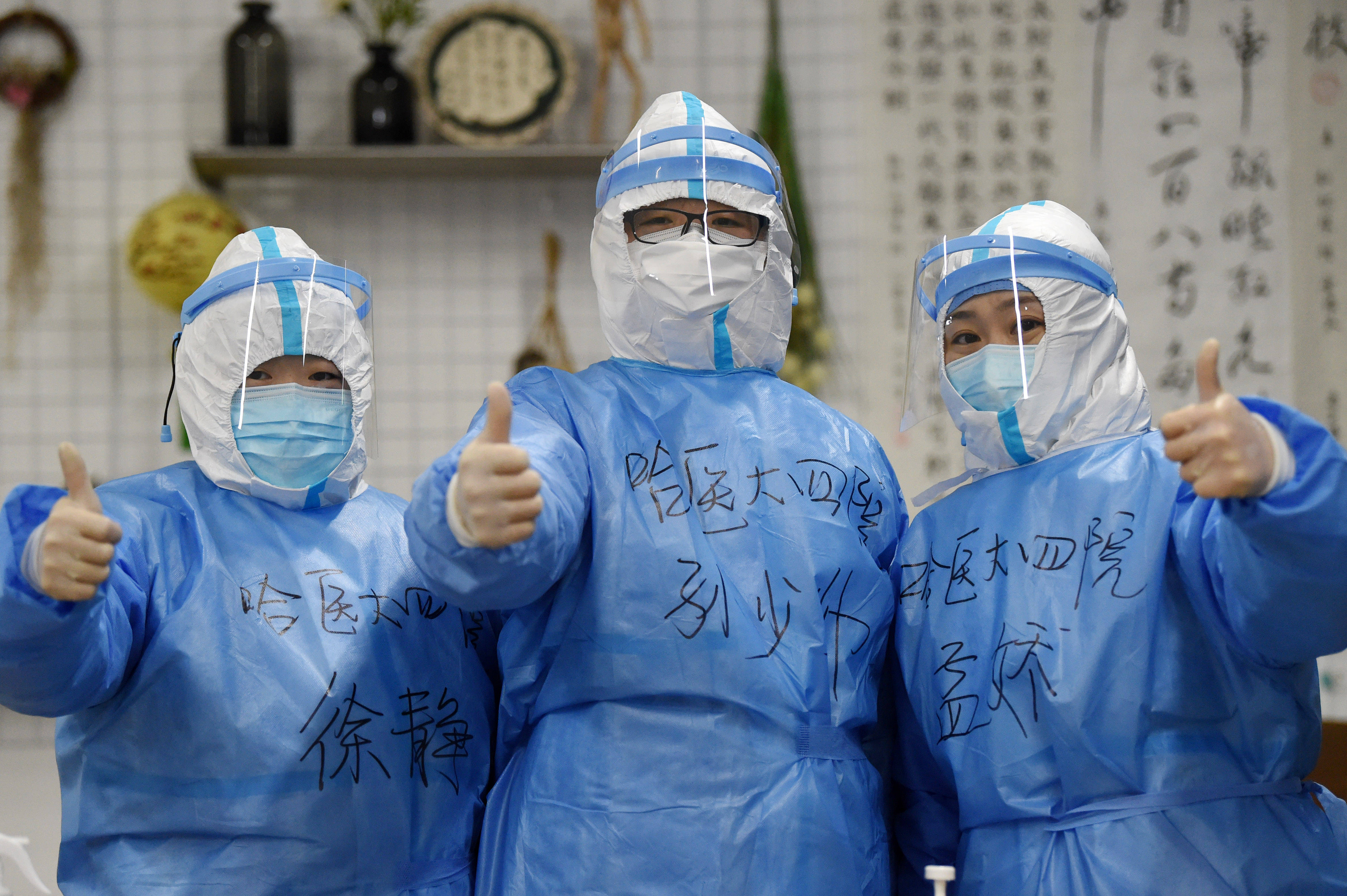 1月22日,在哈尔滨市第一五六中学,医务人员比手势加油