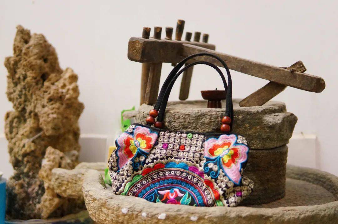 纹样的基底下 再通过一针一线的刺绣手法 被装点在白族服饰的围腰把手