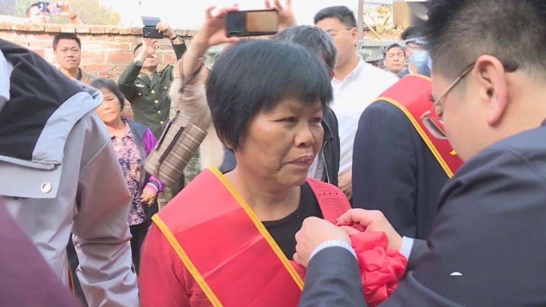报喜团领导为郭子愿家属佩戴绶带,大红花清远军分区