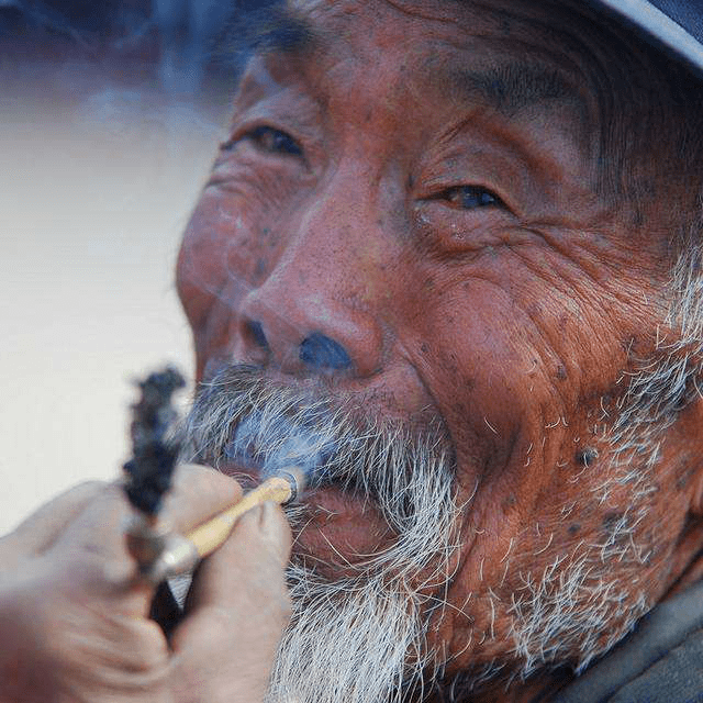 彝族老人抽烟图片图片