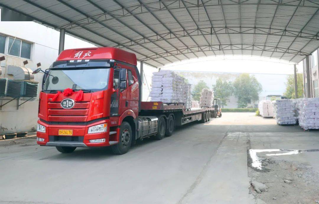 仓库外两辆大货车正在等待上货.