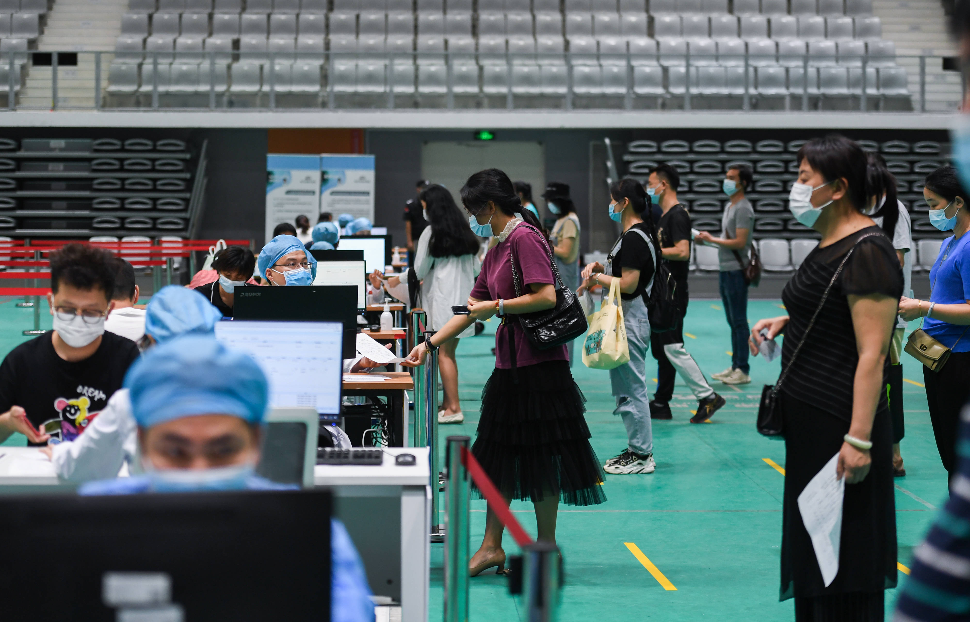 3月29日,在深圳市南山区南山文体中心的临时接种点,市民排队登记接种