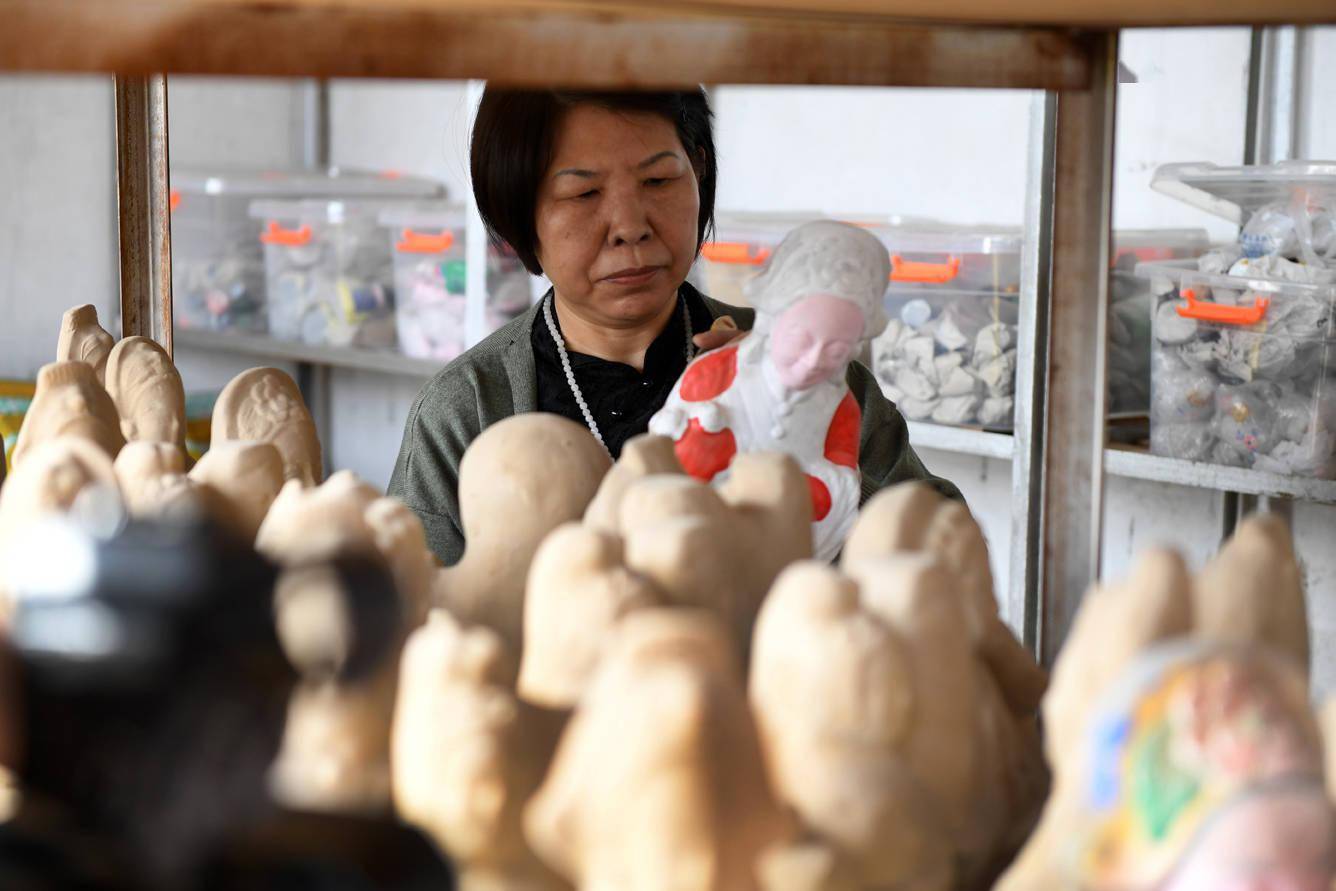 3月30日,白沟镇南刘庄村第四代泥塑传承人胡秋英在工作室检查泥塑产品