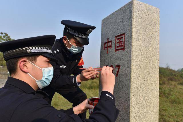 在中国都龙口岸,民警们来到庄严神圣的界碑前,俯下身子仔细擦拭界碑
