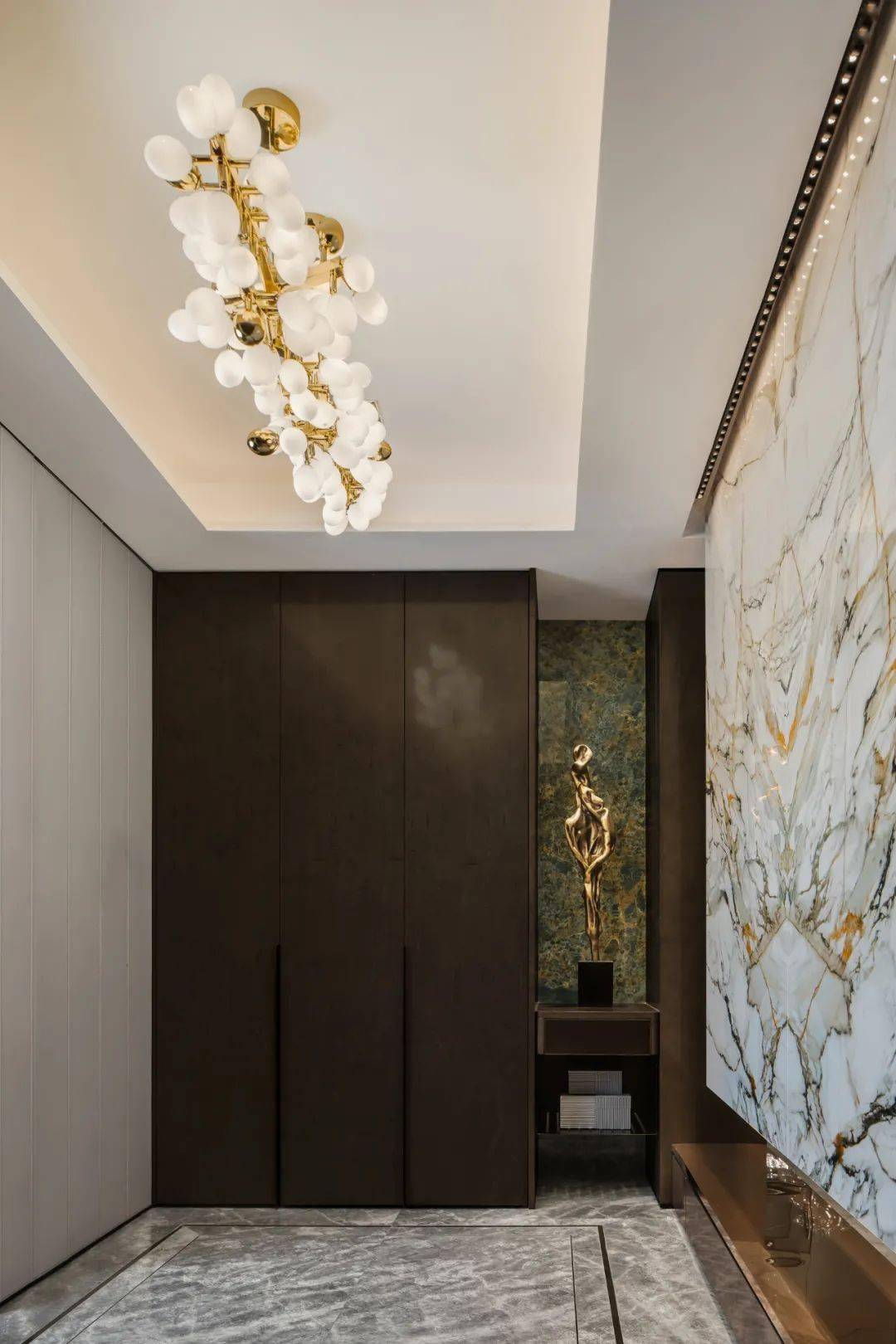 推门而入,一面犹如"影壁"的由顶级岩板打造的经典背景墙,形成了空间